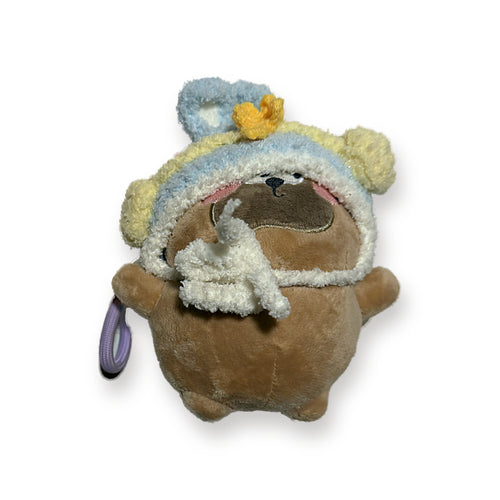 PUUG pug plush bag charm with bunny ears over a blue crochet hat, front view