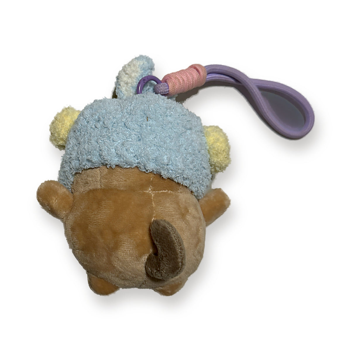 PUUG pug plush bag charm with bunny ears over a blue crochet hat, back view with paracord strap